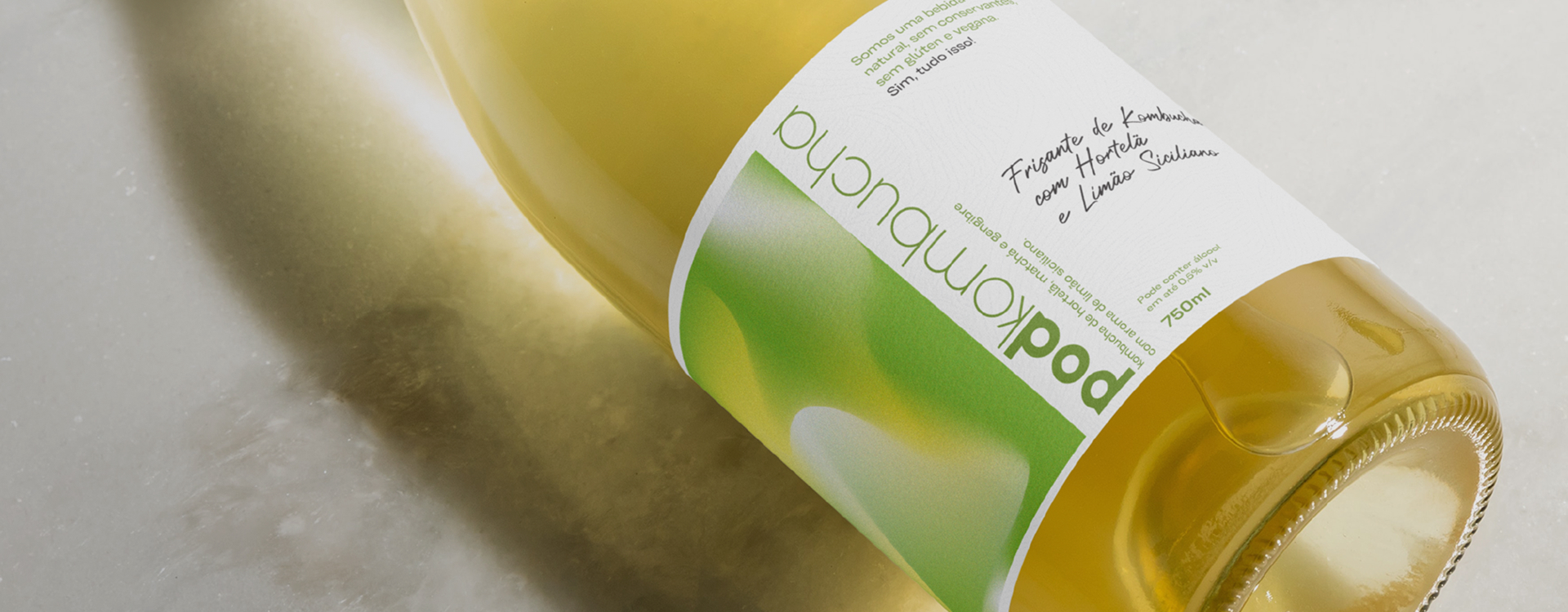 Garrafa deitada mostrando o rótulo do espumante de kombucha Pod